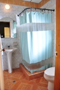 a bathroom with a shower curtain and a sink at Hotel Bahia Blanca Santa Marta Frente al Mar in Santa Marta