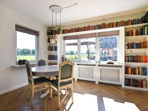 een eetkamer met een tafel en stoelen en boekenplanken bij Relaxing Holiday Home in Hellendoorn with Garden in Hellendoorn