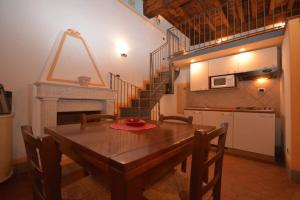 una sala da pranzo con tavolo in legno e scala di Antica Residenza del Gallo a Lucca