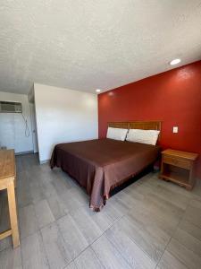 Un dormitorio con una cama con una pared roja. en Red River Inn, en Clarksville