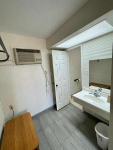a bathroom with a sink and a air conditioner at Red River Inn 
