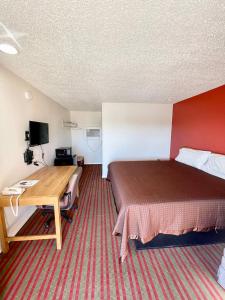 a hotel room with a bed and a desk at Red River Inn 