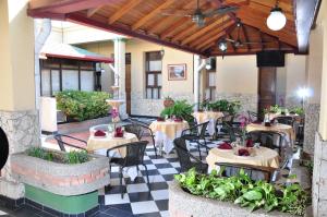 a restaurant with tables and chairs on a checkered floor at Hotel Bahia Blanca Santa Marta Frente al Mar in Santa Marta +26 photos