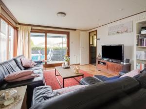ein Wohnzimmer mit einem Sofa und einem TV in der Unterkunft Alluring Chalet in Lith with Terrace and Garden in Lith