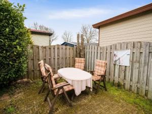 einen Tisch und zwei Stühle neben einem Zaun in der Unterkunft Alluring Chalet in Lith with Terrace and Garden in Lith