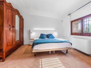 a bedroom with a bed with blue pillows on it at Belvilla by OYO Masmore petit Vulpellac in Vulpellac