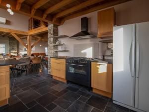 y cocina con fogones y nevera. en Very spacious house with sauna spa and countryside views en Gouvy
