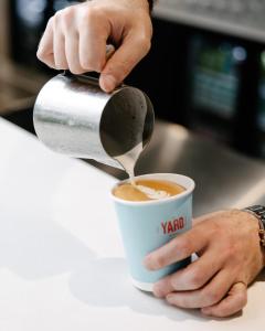 osoba wlewa kawę do kubka w obiekcie Together Co-Living Melbourne w Melbourne