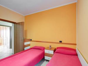 2 Betten in einem Schlafzimmer mit rosa Bettwäsche in der Unterkunft Belvilla by OYO Sirente House in Aielli