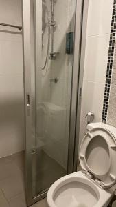 巴吞他尼的住宿－Hotel IYA，一间带卫生间和玻璃淋浴间的浴室