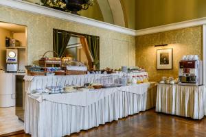 a buffet with white tables with food on them at Albergo Alla Posta in Trieste