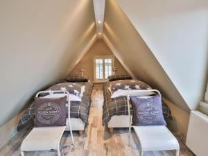 two beds in a attic bedroom with stairs at Holiday home by the Wadden Sea in Paesens