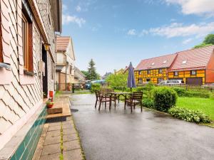 een patio met tafels en stoelen en een gebouw bij Apartment with private terrace in Benneckenstein