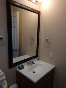 a bathroom with a sink and a large mirror at Anglers Hideaway Cabins Extended Stay in Mead
