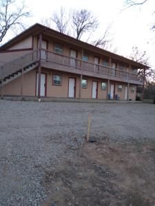 a large house with a balcony on top of it at Anglers Hideaway Cabins Extended Stay in Mead
