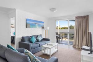 a living room filled with furniture and a large window at Seaside Holiday Resort in Fingal Bay
