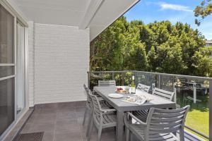 a patio with a table and chairs on a balcony at Seaside Holiday Resort in Fingal Bay