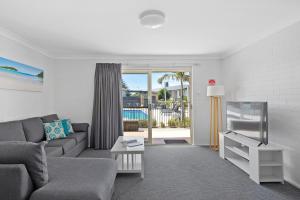 a living room with a couch and a tv at Seaside Holiday Resort in Fingal Bay