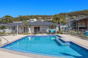 a swimming pool in front of a house at Seaside Holiday Resort in Fingal Bay +55 photos