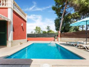 uma piscina com um guarda-sol ao lado de um edifício em Belvilla by OYO Villa Malen s Mallorca em Llucmajor