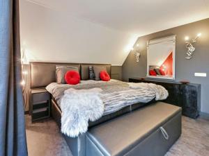 een slaapkamer met een groot bed met rode kussens en een spiegel bij Tasteful Villa in Didam with Garden in Didam