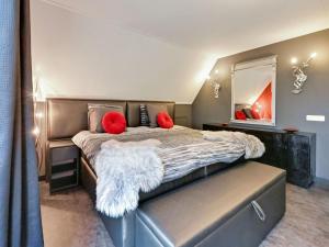 a bedroom with a large bed with red pillows and a mirror at Tasteful Villa in Didam with Garden in Didam