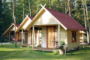 eine kleine Holzhütte mit rotem Dach in der Unterkunft Milleri in Salacgrīva