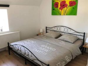 łóżko w sypialni z obrazem na ścianie w obiekcie Charming Home with Garden w mieście Zuienkerke