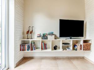 a television on a white shelf in a living room at Holiday home in Koekelare in Koekelare