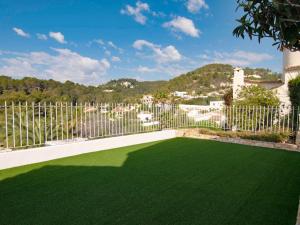 un jardin avec une clôture et une pelouse verdoyante dans l'établissement Belvilla by OYO Mil Flores, à Benissa