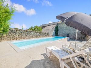 a pool with chairs and an umbrella next to a building at Comfy Holiday Home in Saint-Denis with Private Pool in Saint-Denis