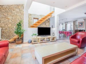 a living room with a tv and a couch and a table at Comfy Holiday Home in Saint-Denis with Private Pool in Saint-Denis