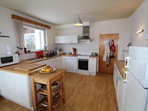 a kitchen with white appliances and a wooden floor at Holiday home in Ludmannsdorf near W rthersee in Ludmannsdorf