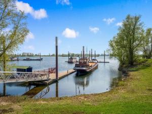 KerkdrielMotorboat Stay on Zandmeren Lake的一艘船停靠在河边的码头
