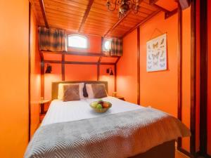 Un dormitorio con una cama con un bol de fruta. en Luxury boat in Kerkdriel, en Kerkdriel