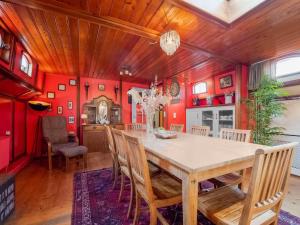 een eetkamer met rode muren en een houten tafel en stoelen bij Luxury boat in Kerkdriel in Kerkdriel