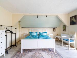 a bedroom with a white bed with blue pillows at Country cottage with Sauna and bubble bath in Kraslice