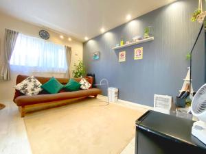 uma sala de estar com um sofá e uma parede azul em Hachi Kamakura KOIWA em Tóquio