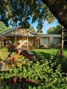 una casa con tavolo da picnic in cortile di Yellowwood Cottage a Himeville