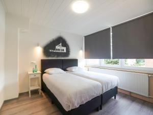 een slaapkamer met een groot bed en een raam bij Terraced house in Kerkrade with a garden in Kerkrade