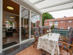 a conservatory with a table and chairs on a patio at Terraced house in Kerkrade with a garden in Kerkrade