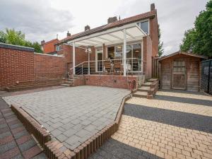 ein Backsteinhaus mit einer großen Terrasse davor in der Unterkunft Terraced house in Kerkrade with a garden in Kerkrade