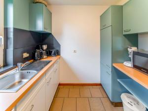 a kitchen with green cabinets and a sink at Escape in Hautes Fagnes in Sourbrodt