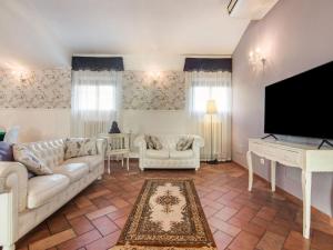 sala de estar con sofá y TV de pantalla plana en Belvilla by OYO La Corte en Fermo