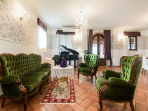 sala de estar con muebles verdes y piano en Belvilla by OYO La Corte en Fermo
