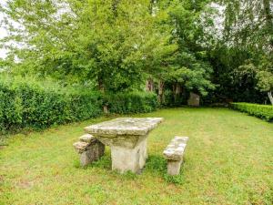 eine auf einem Feld sitzende Steinbank in der Unterkunft Holiday home in Houtteville with garden in Picauville