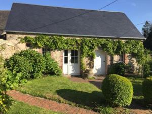 ein Backsteinhaus mit Efeu darauf in der Unterkunft Holiday home in Houtteville with garden in Picauville