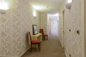 a hallway with chairs and a desk in a room at Albergo Alla Posta in Trieste
