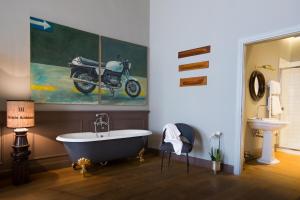 a bathroom with a bath tub and a motorcycle on the wall at Soprarno Suites in Florence