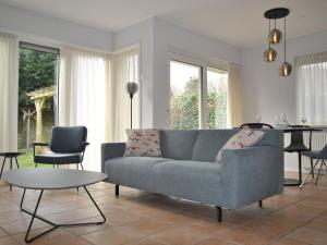 sala de estar con sofá azul y mesa en Bungalow close to seaside resort De Koog en Westermient